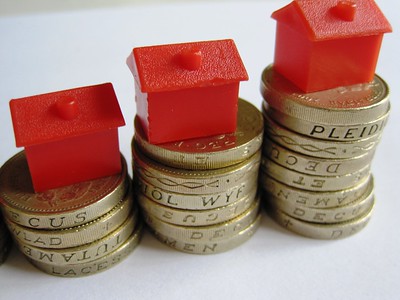 Monopoly houses on top of increasingly tall stacks of coins